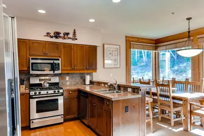 a kitchen with a stove and a sink and a table at Keystone Private Homes by Vail Resorts in Keystone