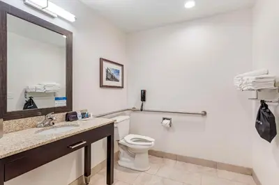 a bathroom with a toilet and a sink and a mirror at Comfort Inn & Suites Brighton Denver NE Medical Center in Brighton