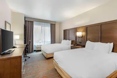 a hotel room with two beds and a flat screen tv at Comfort Inn & Suites Brighton Denver NE Medical Center in Brighton