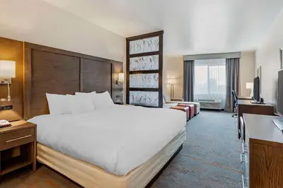 a hotel room with a large bed and a desk at Comfort Inn & Suites Brighton Denver NE Medical Center in Brighton