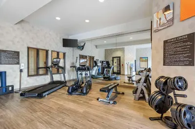 a gym with several treadmills and elliptical machines at Comfort Inn & Suites Brighton Denver NE Medical Center in Brighton