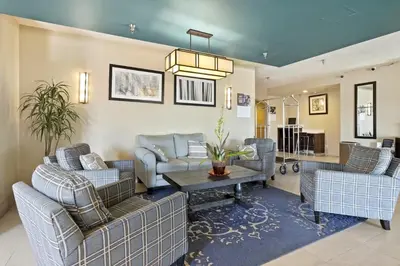 a living room with couches and a table at Baymont by Wyndham Henderson-Northeast Denver in Henderson