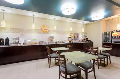 a restaurant with tables and chairs and a counter at Baymont by Wyndham Henderson-Northeast Denver in Henderson