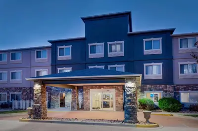 a large blue building with a front porch at Baymont by Wyndham Henderson-Northeast Denver in Henderson