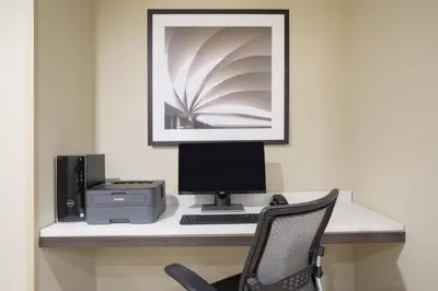 a desk with a computer and a printer and a chair at Candlewood Suites Longmont - Boulder Area by IHG in Longmont