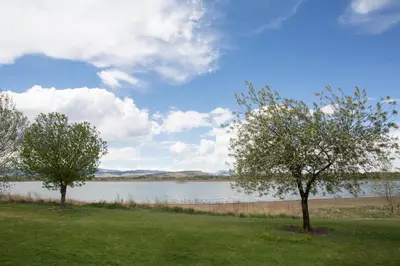 two trees in the grass near a body of water at Candlewood Suites Longmont - Boulder Area by IHG in Longmont