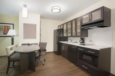 a kitchen with a desk and a table with chairs at Candlewood Suites Longmont - Boulder Area by IHG in Longmont
