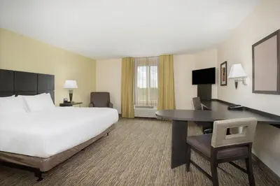 a hotel room with a bed and a desk at Candlewood Suites Longmont - Boulder Area by IHG in Longmont