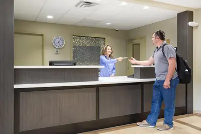 a man and a woman standing at a reception counter at Candlewood Suites Longmont - Boulder Area by IHG in Longmont