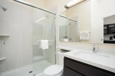 a bathroom with a shower and a toilet and a sink at Candlewood Suites Longmont - Boulder Area by IHG in Longmont