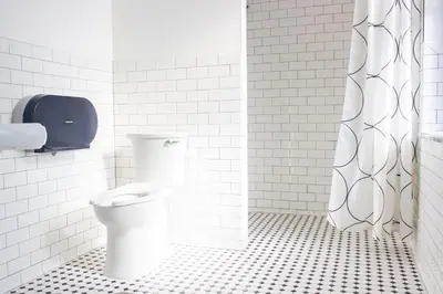 a white bathroom with a toilet and a shower at 11th Avenue Hostel in Denver