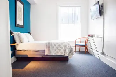 a bedroom with a bed with a blue wall at 11th Avenue Hostel in Denver