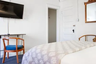 a bedroom with a bed and a desk and a television at 11th Avenue Hostel in Denver