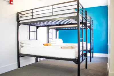 a black bunk bed with white sheets and pillows at 11th Avenue Hostel in Denver