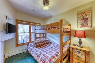 a bedroom with a bunk bed and a tv at Hidden River Lodge 5975 in Keystone