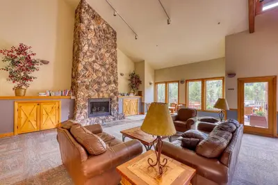 a living room with leather furniture and a stone fireplace at Hidden River Lodge 5975 in Keystone