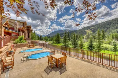 an outdoor patio with a table and chairs and a pool at Hidden River Lodge 5975 in Keystone