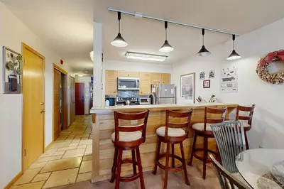 a kitchen with a bar with wooden stools at Ski Run Condominiums 203 in Keystone