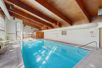 a swimming pool in a building with a wooden ceiling at Ski Run Condominiums 203 in Keystone