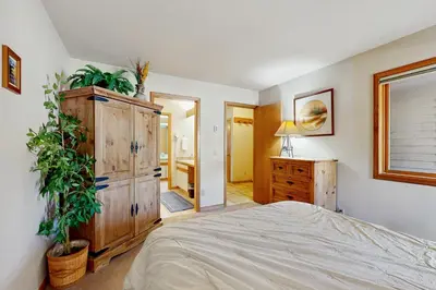 a bedroom with a bed and a dresser with plants at Ski Run Condominiums 203 in Keystone
