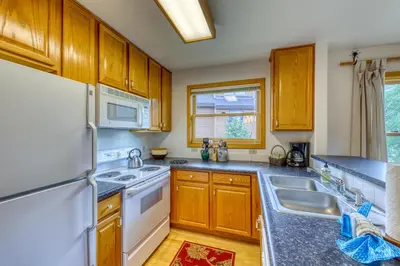 a kitchen with wooden cabinets and a white refrigerator at Snake River Village 05 in Keystone