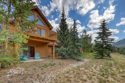 a log home with a deck and trees at Snake River Village 05 in Keystone