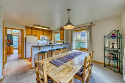 a kitchen and dining room with a wooden table and chairs at Snake River Village 05 in Keystone