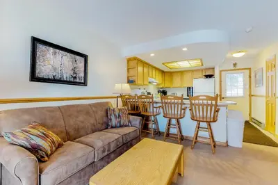 a living room with a couch and a kitchen at Snowdance Condo A101 in Keystone