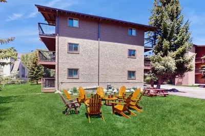 a group of chairs and tables in front of a building at Snowdance Condo A101 in Keystone