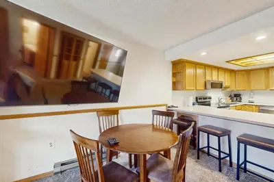 a kitchen with a wooden table and chairs at Snowdance Condo A101 in Keystone