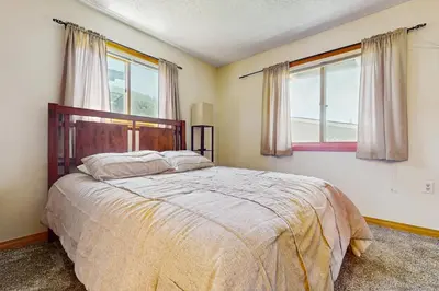 a bedroom with a bed and two windows at Snowdance Condo A101 in Keystone