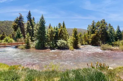 a large river with trees and a bridge at Snowdance Condo A101 in Keystone