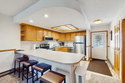 a kitchen with wooden cabinets and a white counter top at Snowdance Condo A101 in Keystone