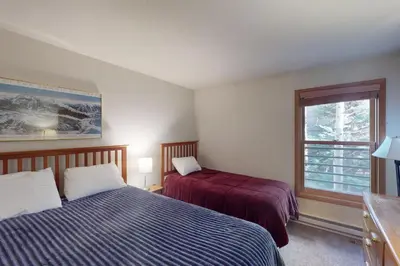 a bedroom with two beds and a window at Snowdance Manor 205 in Keystone