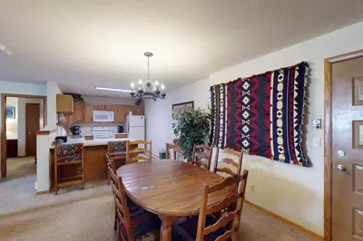a kitchen and dining room with a wooden table and chairs at Snowdance Manor 205 in Keystone