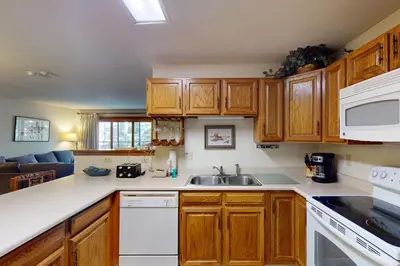 a kitchen with wooden cabinets and a sink at Snowdance Manor 205 in Keystone