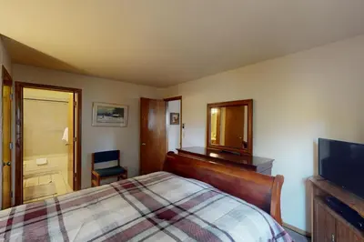 a bedroom with a bed and a mirror and a television at Snowdance Manor 205 in Keystone