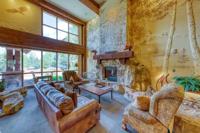 a living room filled with furniture and a stone fireplace at Springs Lodge 8888 in Keystone