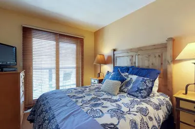a bedroom with a blue and white bed with a television at Springs Lodge 8888 in Keystone
