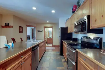 a kitchen with wooden cabinets and stainless steel appliances at Springs Lodge 8888 in Keystone