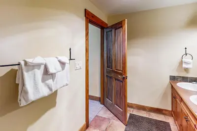 a bathroom with a sink and a wooden door at Springs Lodge 8906 in Keystone