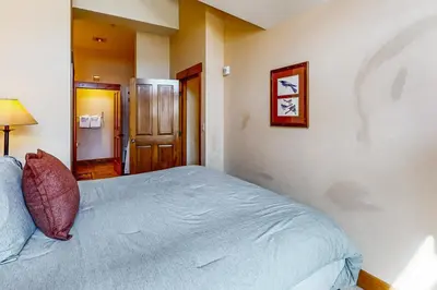 a bedroom with a bed with a blue comforter at Springs Lodge 8906 in Keystone