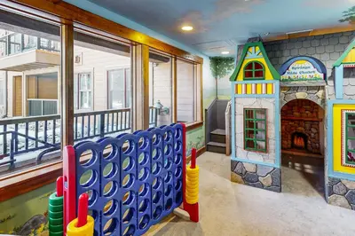 a childrens room with a play room with a house and a playground at Springs Lodge 8906 in Keystone
