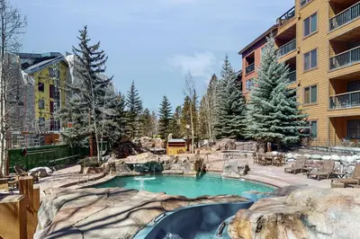 a swimming pool with a waterfall in a resort at Springs Lodge 8906 in Keystone