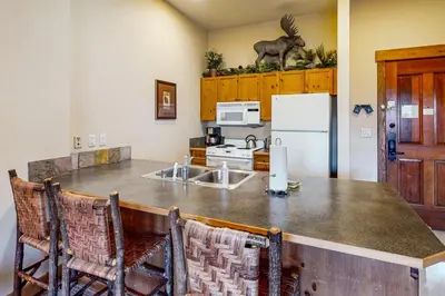 a kitchen with a counter with a sink and a refrigerator at Springs Lodge 8906 in Keystone
