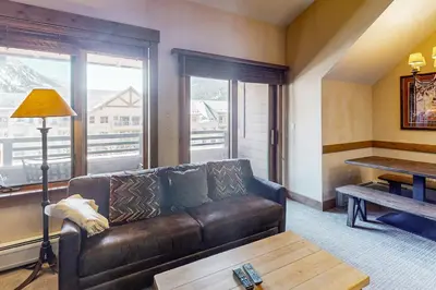 a living room with a leather couch and a table at Springs Lodge 8906 in Keystone