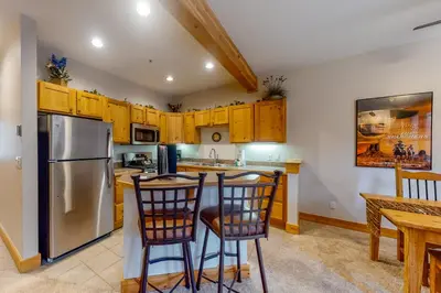 a kitchen with wooden cabinets and a stainless steel refrigerator at Trappers Crossing 8763 in Keystone