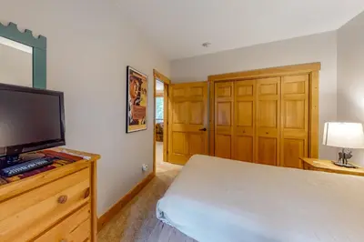 a bedroom with a bed and a flat screen tv at Trappers Crossing 8763 in Keystone