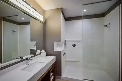 a bathroom with a shower and a sink and a mirror at Courtyard by Marriott Denver Southwest/Littleton in Littleton