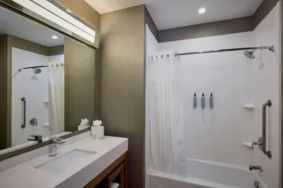 a bathroom with a shower and a sink and a mirror at Courtyard by Marriott Denver Southwest/Littleton in Littleton